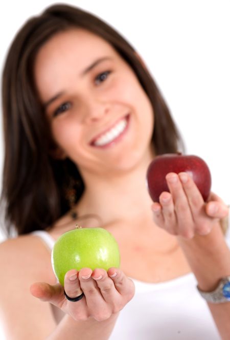 beautiful girl smiling while holdin a green and a red apple over a white background