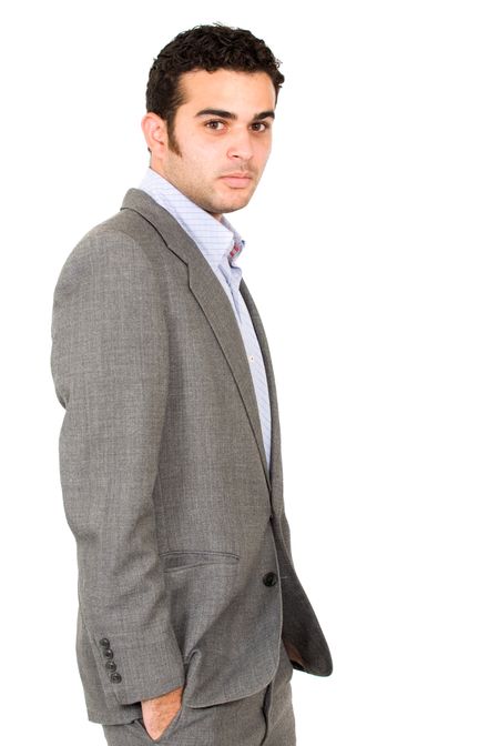 confident business man with hands in pockets over a white background