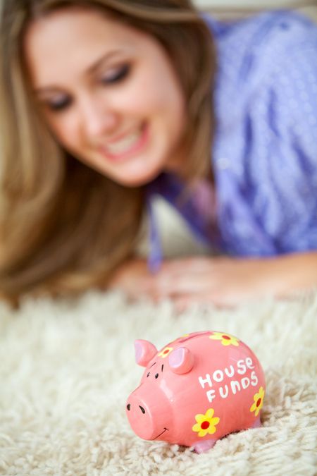 Woman with a piggy bank thinking about the house funds