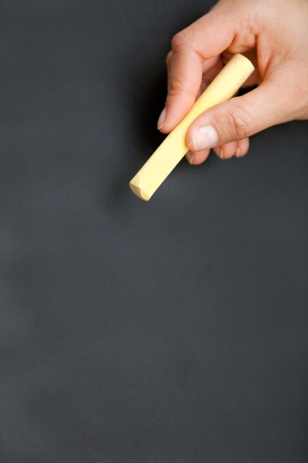 Blackboard with a hand holding a yellow chalk