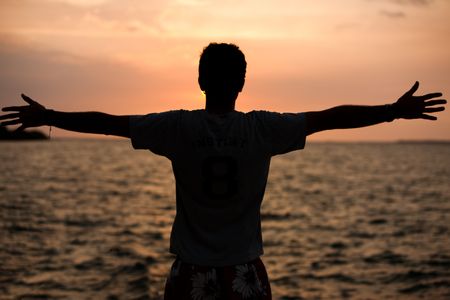 man-arms-opened-watching-sunset-31633912 Man with his arms opened watching the sunset