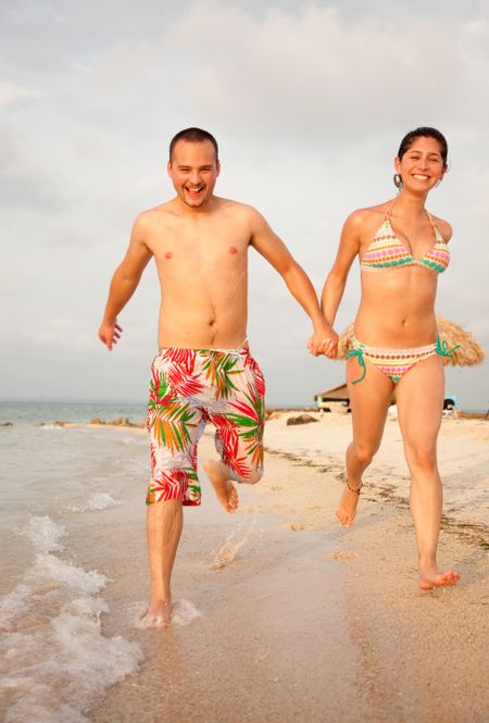 Happy young couple running on the beach