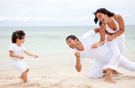 Children against parents competing at the beach