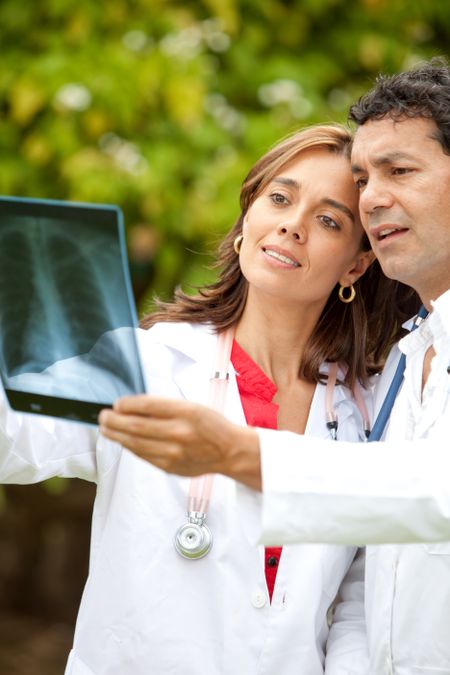 couple of doctors looking at an x-ray outdoors