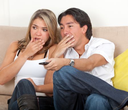 Scared couple watching a scary movie
