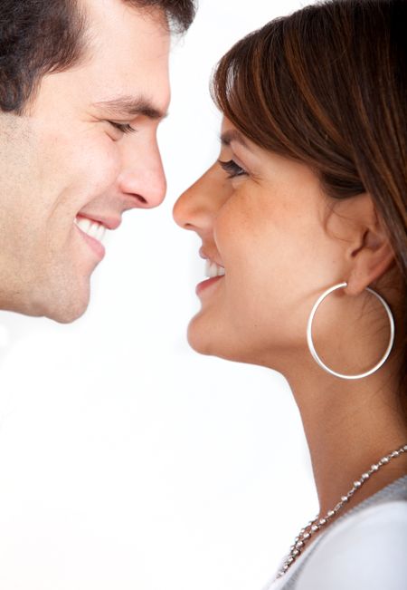Couple facing each other and smiling isolated over a white background