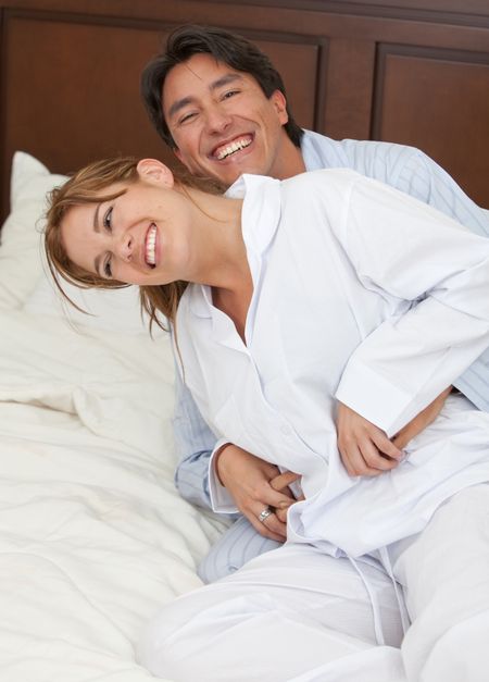 Beautiful couples portrait playing on the bed