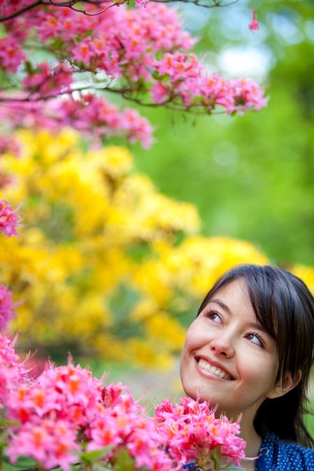 casual woman smiling outdoors with some flowers