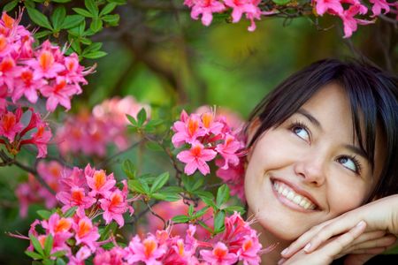 Beautiful woman smiling outdoors with some flowers