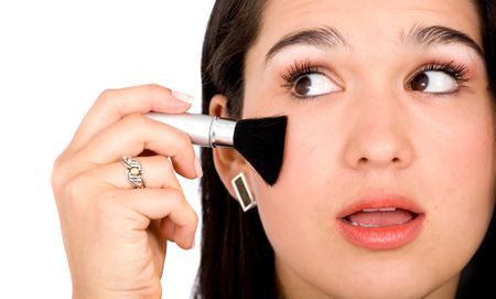 beautiful girl applying makeup on her cheek - over a white background