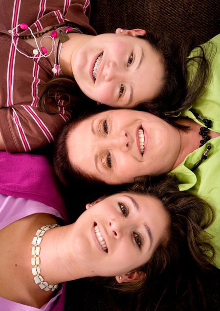 Beautiful mother and daughters portrait on the floor with heads up