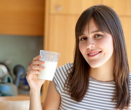 Beautiful girl holding a glass of milk
