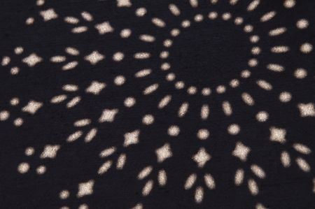 Pattern of sunlight from seat of patio chair on pavement