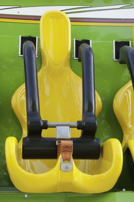 Yellow seat with black safety bar on carnival ride