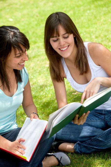 Couple of girls studying at the park