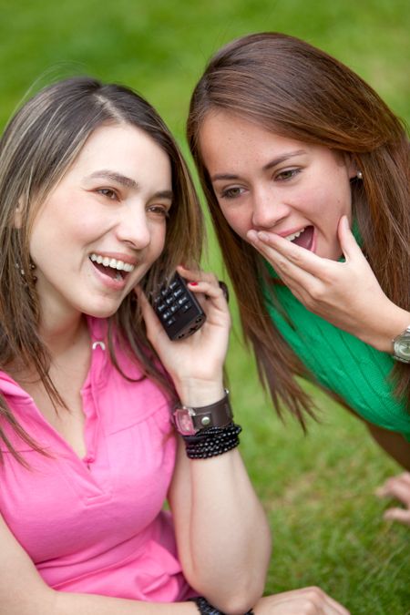 Girls smiling and  talking on the phone outdoors