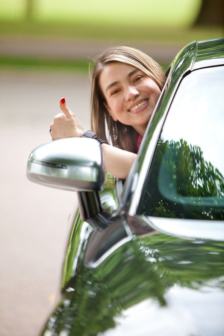Happy woman sticking her head out of a car's window