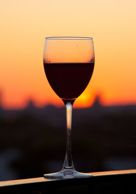 Glass of wine with a beautiful sunset as the background