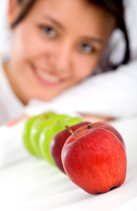 healthy girl eating apples over a white background with the focus on the first apple