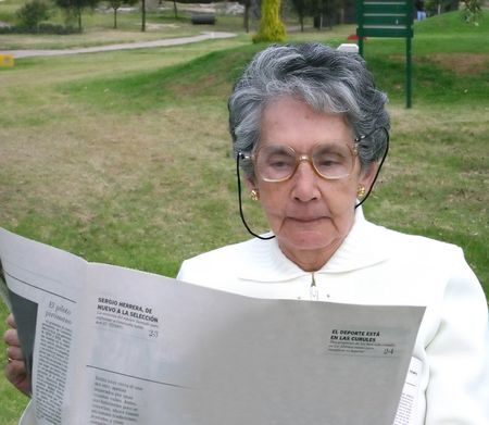 retired woman reading newspaper outdoors 2
