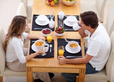 Beautiful couple eating their breakfast at home