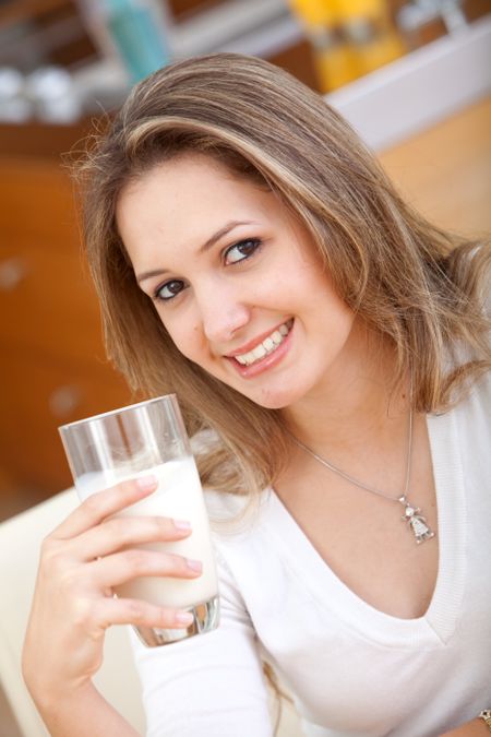 Beautiful girl drinking a glass of milk