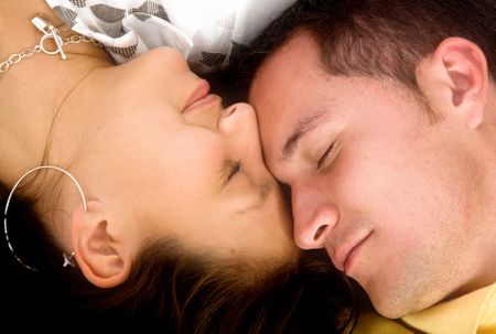 beautiful couple in love sleeping with heads together on the floor