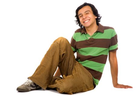 casual guy on the floor with a big smile isolated over a white background