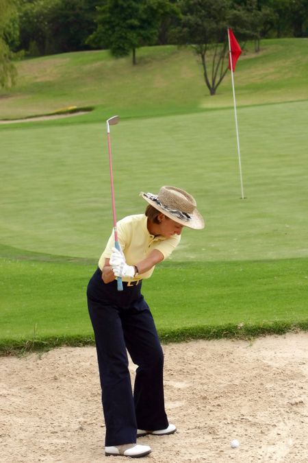 female golfer in a bunker