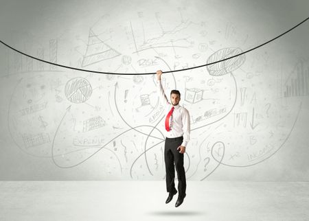 Businessman hanging on a rope with analysis and graphs background
