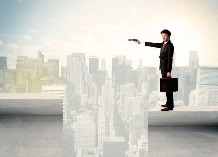 Businessman standing on the edge of rooftop with city background