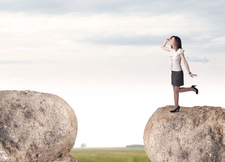 Young businesswoman standing on edge of rock mountain