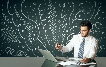 Businessman sitting at table with drawn curly lines and arrows on the background
