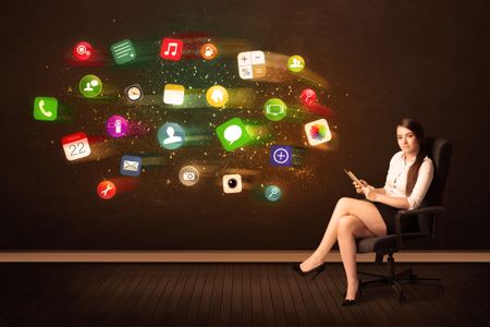 Business woman sitting in office chair with tablet and colorful app icons concept on background