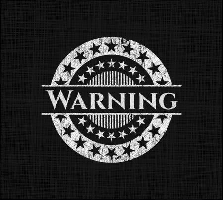 Warning chalkboard emblem written on a blackboard