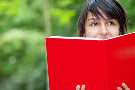 female university student with a notebook outdoors
