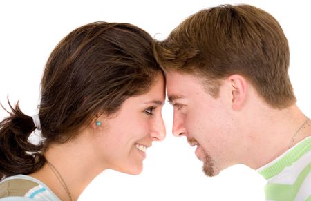 Beautiful couple face to face looking at each other smiling over a white background