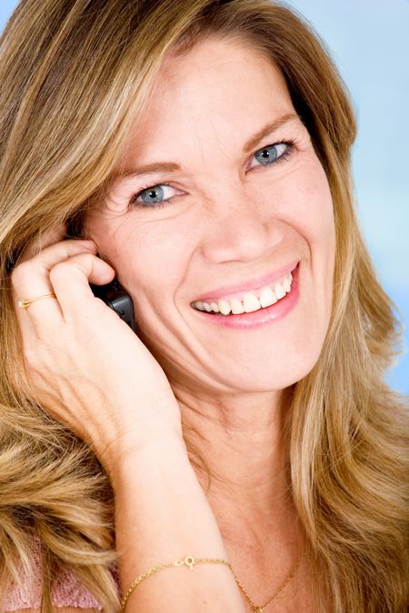 senior woman smiling on the phone over a blue background
