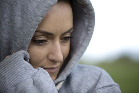Young woman on a cold morning in a hooded top before going out for a run