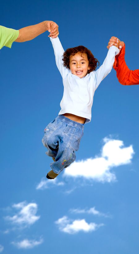 child having fun with his parents outdoors with a blue sky in the background