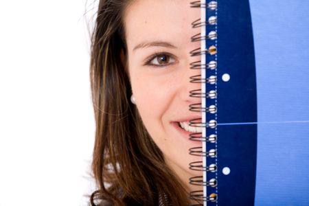 female student peeping behind a notebook - isolated over a white background