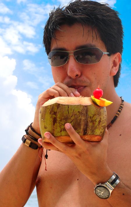 guy enjoying a cocktail at the beach on a sunny day