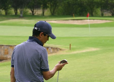 male golfer looking at his club