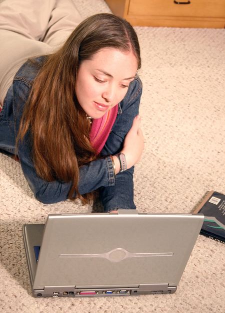 girl studying on a laptop on the floor