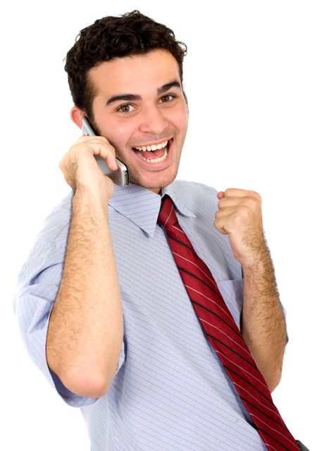 Business man looking happy when receiving good news of success by phone - isolated over a white background