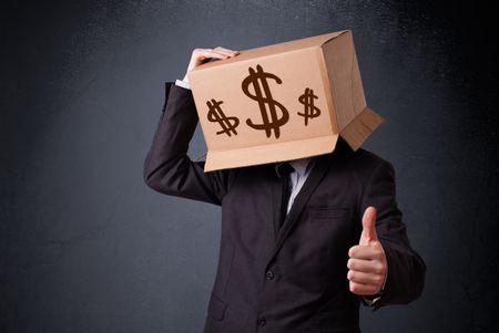 Young man standing and gesturing with a cardboard box on his head with dollar signs