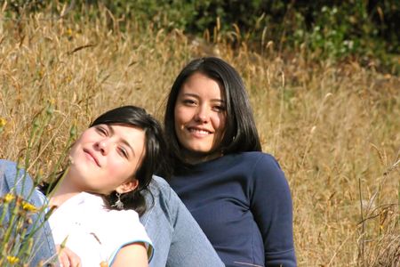 couple of sisters relaxing on the grass in the countryside