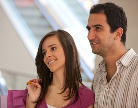 pretty couple shopping looking at a window and smiling