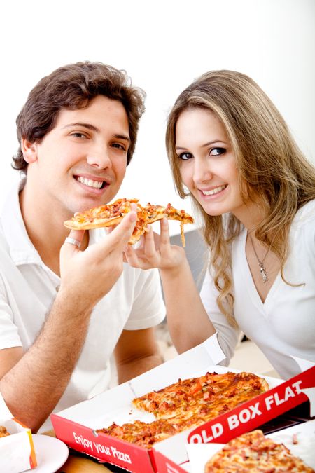 Beautiful couple eating pizza isolated over white