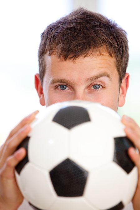 Man covering his face with a football isolated